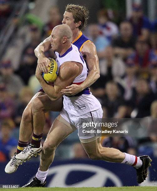 Barry Hall of the Bulldogs is tackled by Troy Selwood of the Lions during the round four AFL match between the Brisbane Lions and the Western...