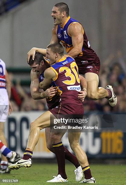 Jonathan Brown of the Lions celebrates with team mates Brendan Fevola and Jack Redden after scoring a goal during the round four AFL match between...
