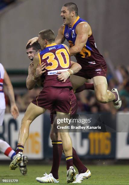 Jonathan Brown of the Lions celebrates with team mates Brendan Fevola and Jack Redden during the round four AFL match between the Brisbane Lions and...