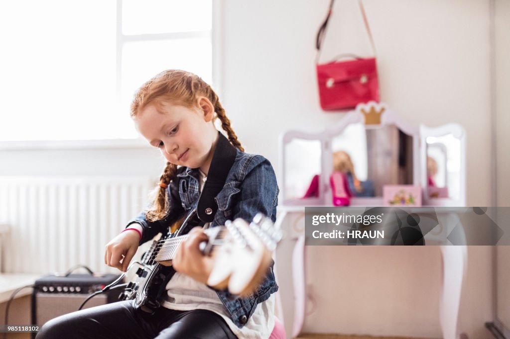 Girl playing on an electric guitar