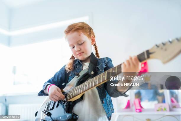 girl playing electric guitar in here room at home. - pop musician stock pictures, royalty-free photos & images