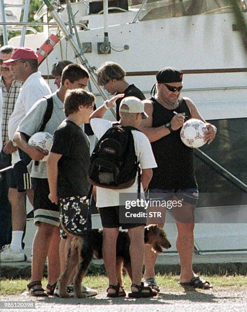 Argentine ex-soccer player Diego Armando Maradona signs a ball with children 30 January 2000 at Hemingway Marina in Havana where he is undergoing...
