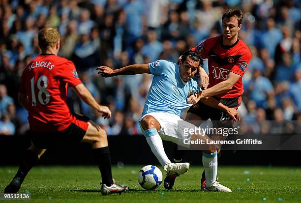 Carlos Tevez of Manchester City battles for the ball with Jonny Evans of Manchester United during the Barclays Premier League match between...