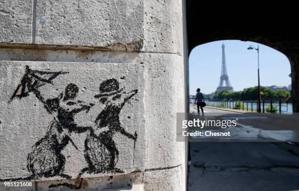 Recent work by street artist Banksy is seen on a wall next to the Eiffel Tower on June 27, 2018 in Paris, France. The British artist Banksy confirmed...