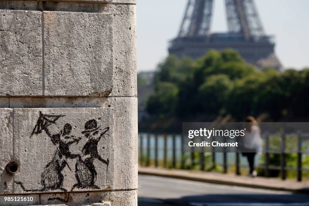 Recent work by street artist Banksy is seen on a wall next to the Eiffel Tower on June 27, 2018 in Paris, France. The British artist Banksy confirmed...