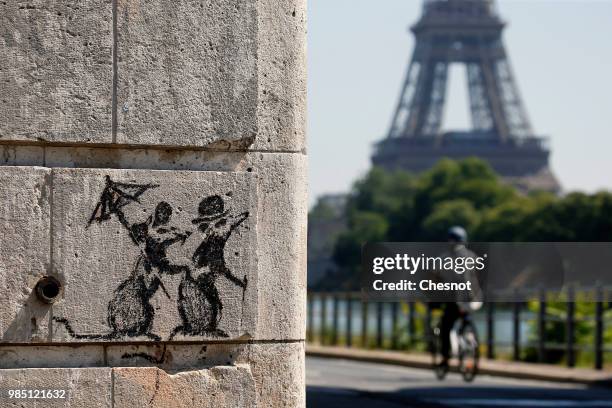 Recent work by street artist Banksy is seen on a wall next to the Eiffel Tower on June 27, 2018 in Paris, France. The British artist Banksy confirmed...