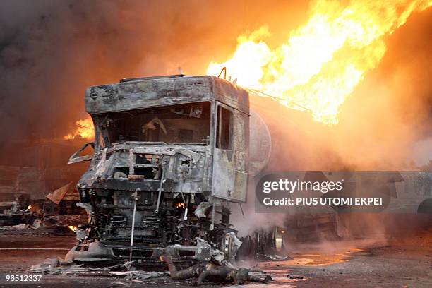 Burnt man lies at the foot of a tanker on fire, on Lagos Ibadan Highway in Ibafo in the early hours of April 17, 2010. Two tankers filled with petrol...