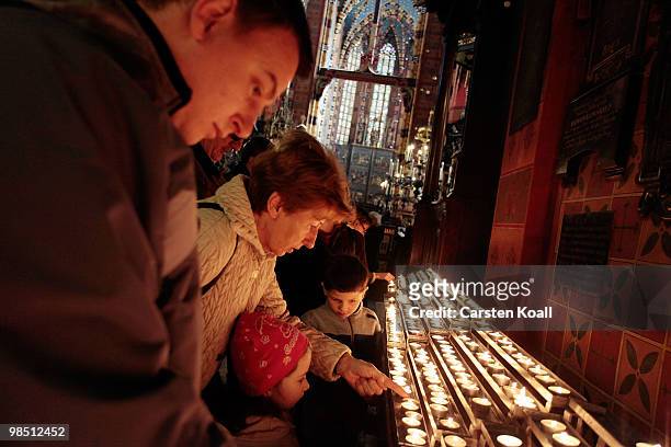 Girl lights a candle in the St Mary's Basilica on April 17, 2010 in Krakow, Poland. The funeral ceremony of late Polish President Lech Kaczynski will...