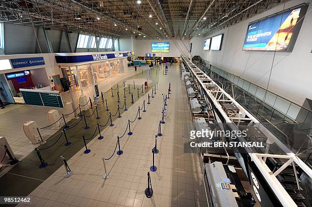 Terminal at the Birmingham International Airport is empty of passengers on April 17 in Birmingham. Britain has extended a ban on most flights in its...