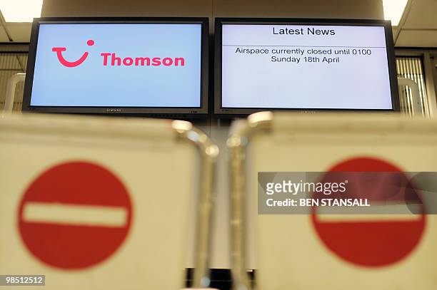 An information board informing passengers of a UK airspace closure is seen in a deserted terminal at the Birmingham International Airport in...