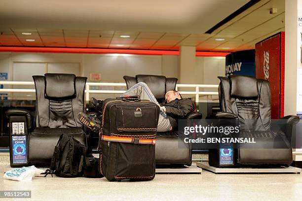 Passenger sleeps in a deserted terminal at the Birmingham International Airport in Birmingham, central England, on April 17, 2010. Britain has...