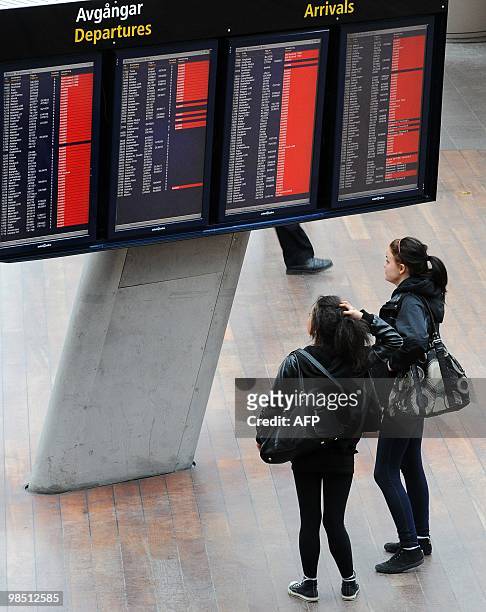 Two women check departure information at Arlanda airport in Stockholm on April 17, 2010. Millions of people faced worsening travel chaos today as a...