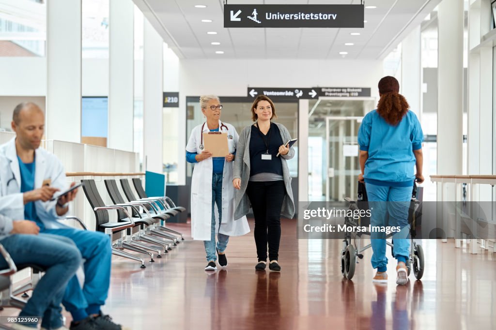 Doctors And Patient In Hospital Corridor