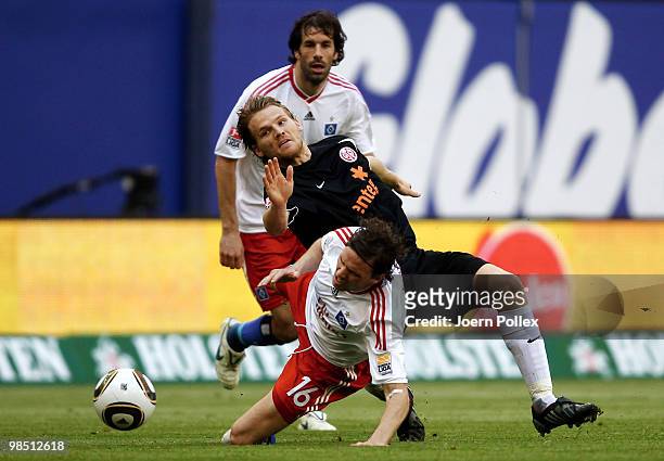 Marcus Berg and Ruud van Nistelrooy of Hamburg as well as Eugen Polanski of Mainz compete for the ball during the Bundesliga match between Hamburger...