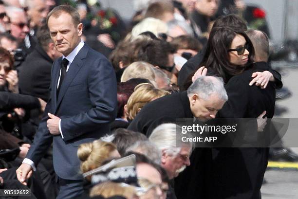 Late Polish President Lech Kaczynski's daughter Marta hugs Maciej Lopinski, Director of the Presidential cabinet next to her uncle Jaroslaw Kaczynski...