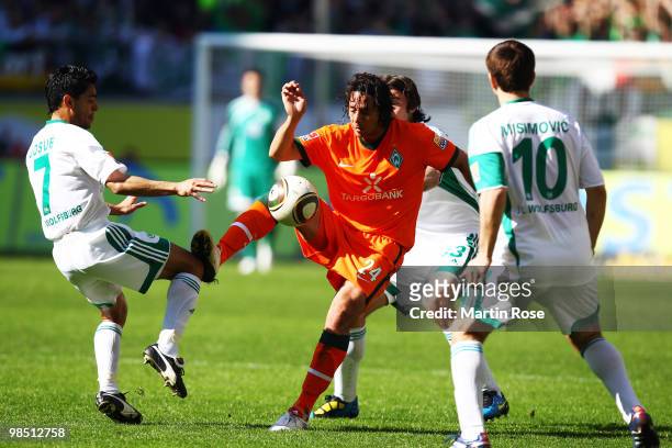 Josue of Wolfsburg and Claudio Pizarro of Bremen battle for the ball during the Bundesliga match between VfL Wolfsburg and SV Werder Bremen at the...