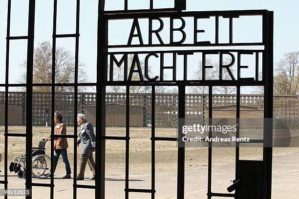 Jerzy Milewski, survivor of the Holocaust, and his daugther Maria behind the entrance gate marked with the inscription 'Arbeit Macht Frei' during...