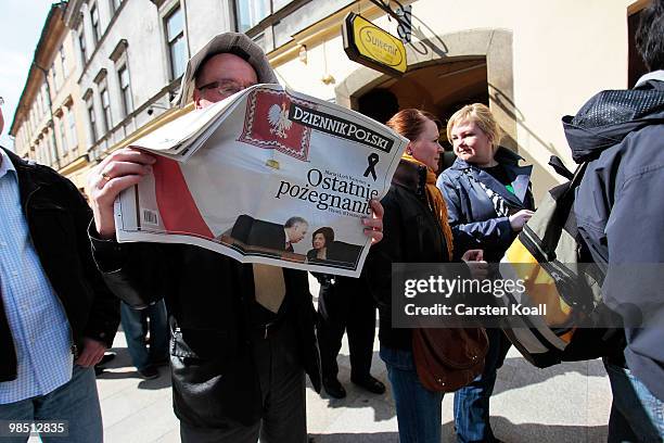 Man reads an polish daily newspaper waiting in the line where tickets to the ceremony of mourning of Polish President Lech Kaczynski and his wife...