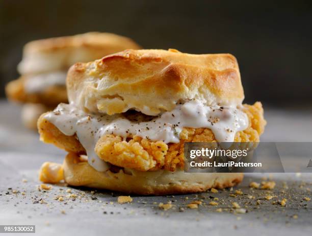 fried chicken sandwich mit wurst soße auf einen keks - buttermilk biscuit stock-fotos und bilder