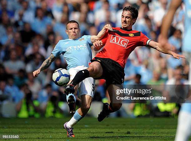 Craig Bellamy of Manchester City competes for the ball with Gary Neville of Manchester United during the Barclays Premier League match between...