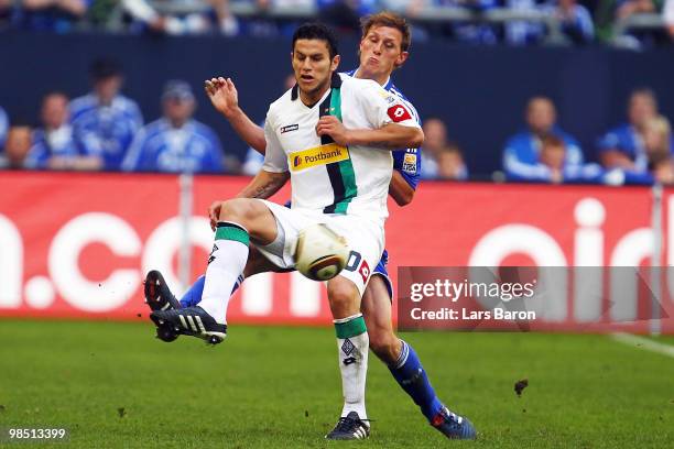 Raul Bobadilla of Moenchengladbach is challenged by Benedikt Hoewedes of Schalke during the Bundesliga match between FC Schalke 04 and Borussia...
