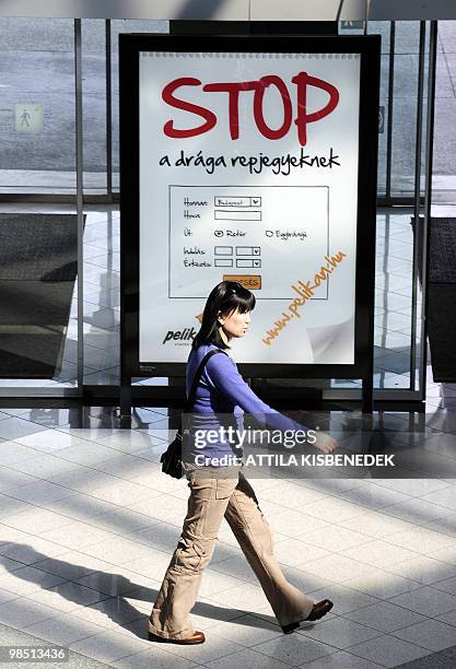 Woman walks in front of an advertising board at the Budapest-Ferihegy Airport on April 17, 2010 as flights were cancelled due to a cloud of ash...