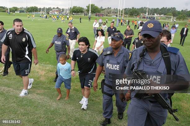 Armed police walk around Argentinian soccer head coach Diego Maradona during his visit of High Performance Center in Pretoria on January 18, 2010. He...