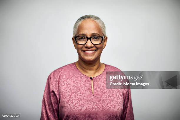 senior woman smiling over white background - frau gesicht brille stock-fotos und bilder