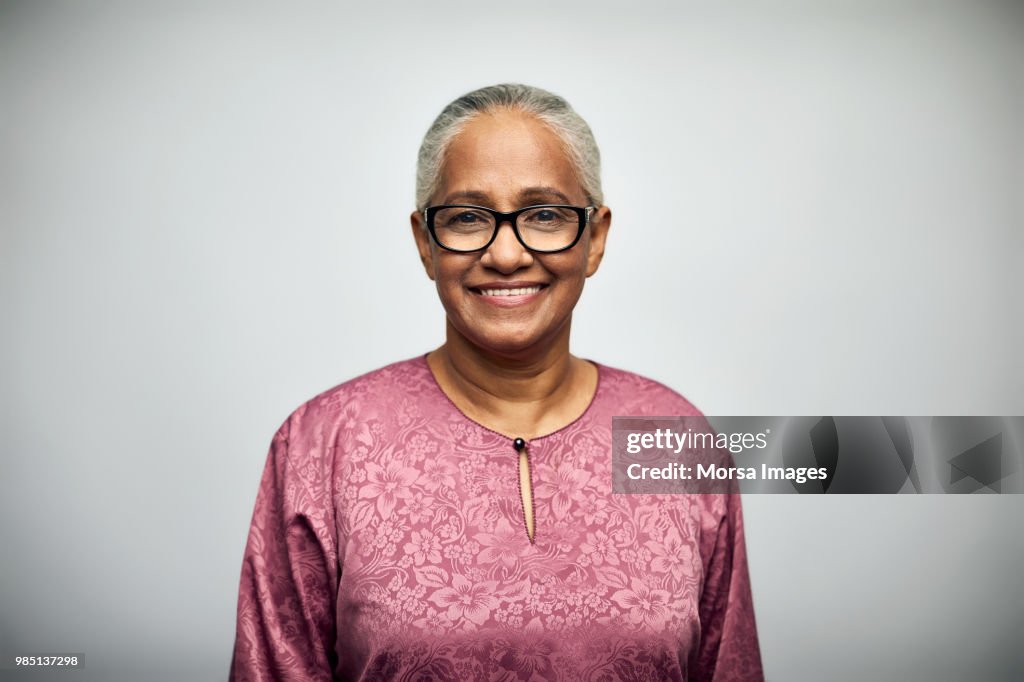 Senior woman smiling over white background