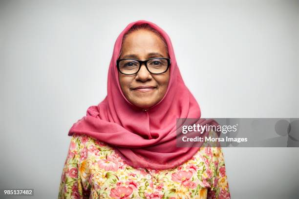 portrait of smiling senior woman wearing hijab - islamismo fotografías e imágenes de stock