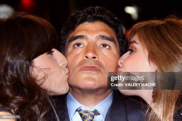 Former Argentinian football player Diego Maradona is kissed bu his daughters Giannina and Dalma as he arrives to attend the screening of Serbian...