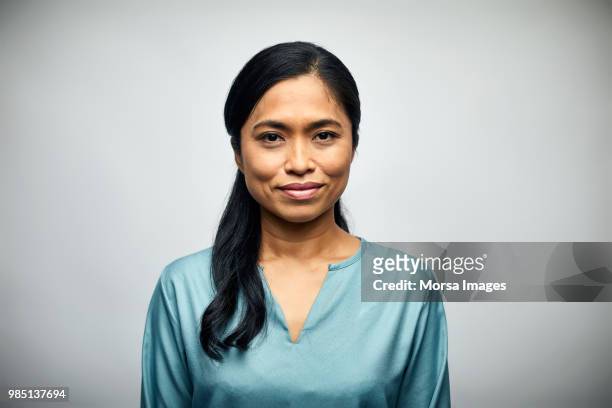 mid adult woman smiling over white background - zuidoost aziatische etniciteit stockfoto's en -beelden