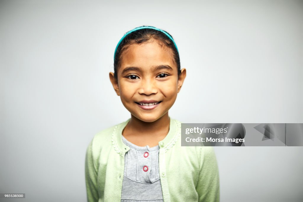 Portrait of cute girl smiling on white background