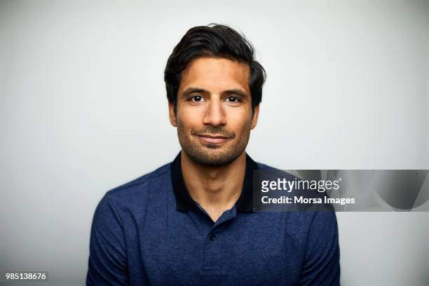 handsome mid adult man smiling on white background - indian faces stock-fotos und bilder