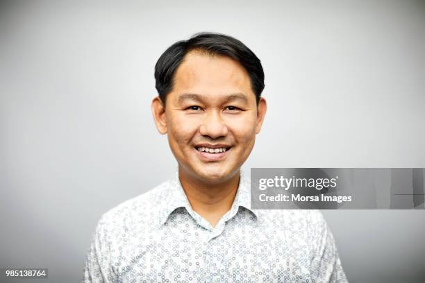 mid adult businessman smiling on white background - character faces asian stock-fotos und bilder