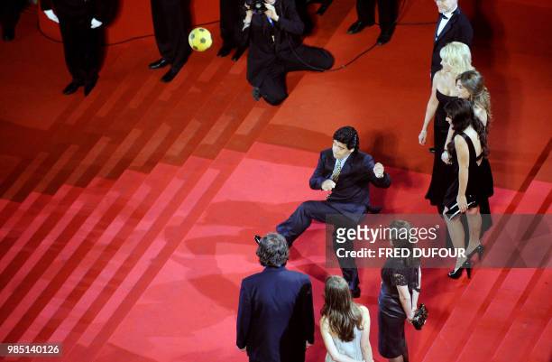 Former Argentinian football player Diego Maradona dribbles with a ball as he arrives with his relatives to attend the screening of Serbian director...