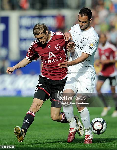 Oemer Toprak of Freiburg battles for the ball with Marcel Risse of Nuernberg during the Bundesliga match between SC Freiburg and 1.FC Nuernberg at...