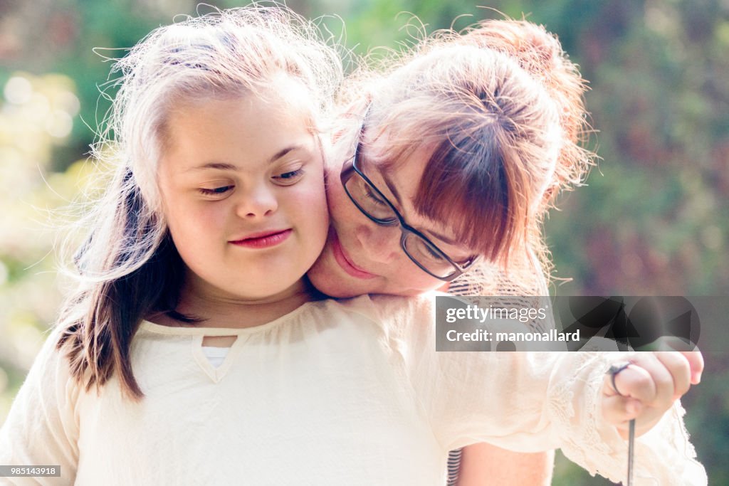 Retrato de uma mãe com sua filha de 12 anos com autismo e síndrome de Down no cotidiano