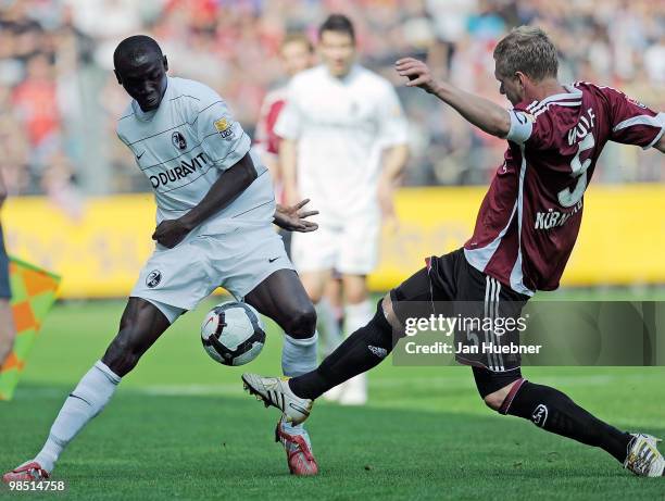 Papiss Demba Cisse of Freiburg battles for the ball with Andreas Wolf of Nuernberg during the Bundesliga match between SC Freiburg and 1.FC Nuernberg...