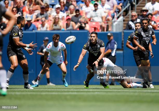 Dallin Watene-Zelezniak of New Zealand passes the ball to a teammate as he's tackled by James Roby of England during a Rugby League Test Match...