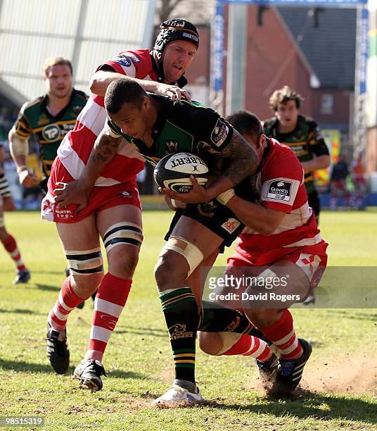 Courtney Lawes of Northampton is tackled by Paul Doran-Jones and Peter Buxton during the Guinness Premiership match between Northampton Saints and...