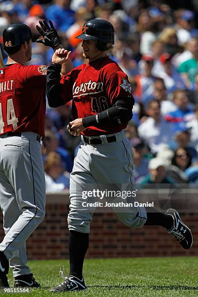 Towles of the Houston Astros is congratulated by pitcher Roy Oswalt after hitting a home run in the 5th inning against the Chicago Cubs at Wrigley...