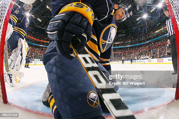 Ryan Miller watches as his teammate Henrik Tallinder of the Buffalo Sabres reaches into the back of the net for the puck after a second period goal...