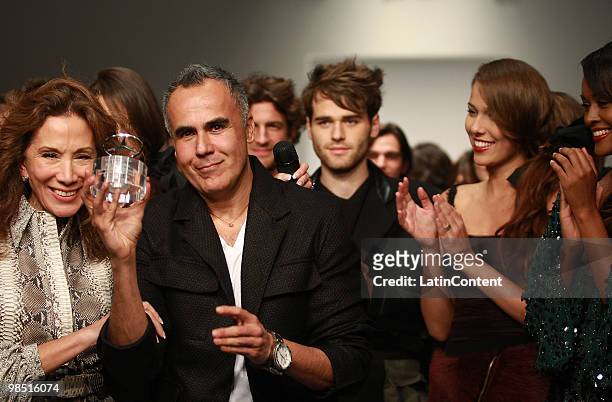 Fashion designer Ricardo Seco greets the audience at the end of his fashion show during the Mercedes-Benz Fashion Week 2010 at Campo Marte on April...