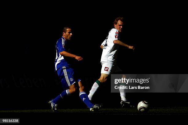 Lukas Schmitz of Schalke is challenged by Tobias Levels of Moenchengladbach during the Bundesliga match between FC Schalke 04 and Borussia...