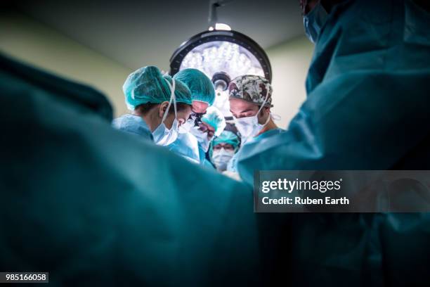 view of the surgery room with doctors and surgeons performing an operation - healthcare complexity stock pictures, royalty-free photos & images