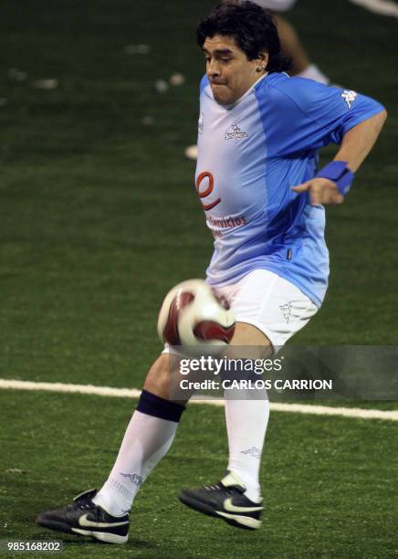 Argentine former soccer star Diego Maradona controls the ball in a showball match against Uruguay in Rosario, in the Argentine province of Santa Fe,...