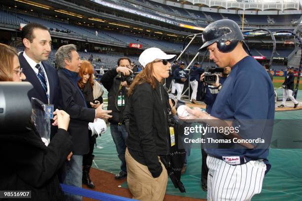 Yankee Infielder Alex Rodriguez autographs a baseball for Donna Karan at Yankee Stadium on April 16, 2010 in Bronx borough of New York City.