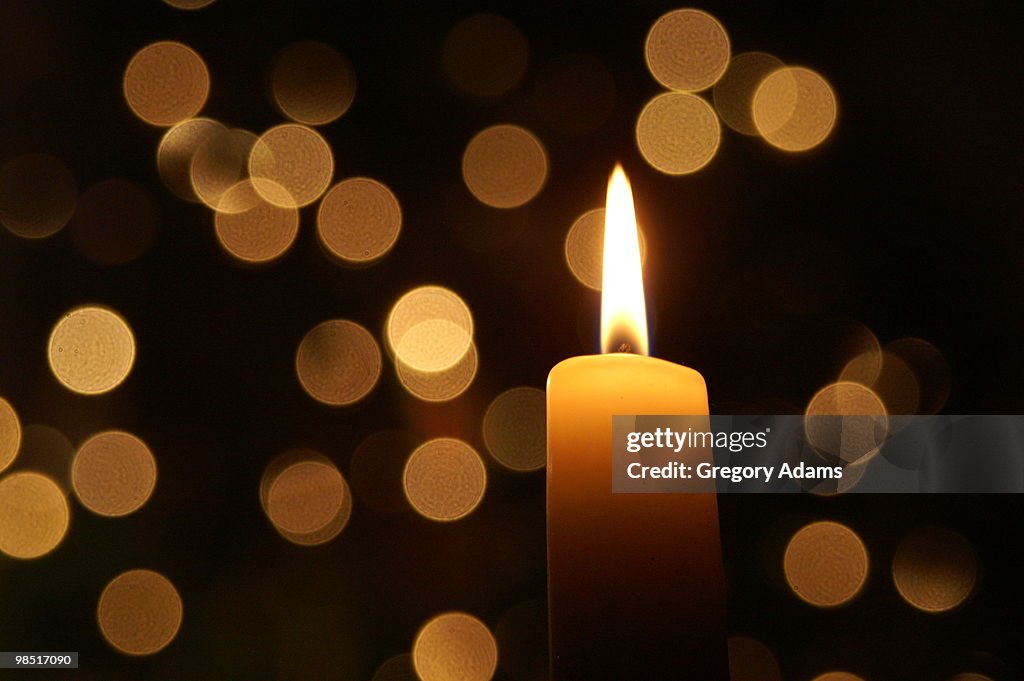 Christmas Candle with lights in the background