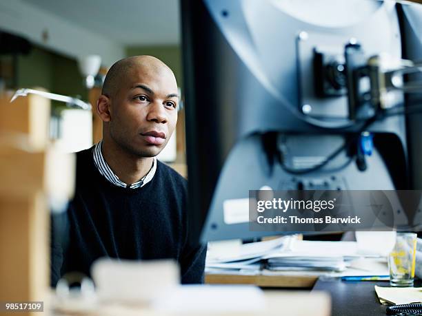 businessman working on computer at desk in office - newbusiness stock pictures, royalty-free photos & images